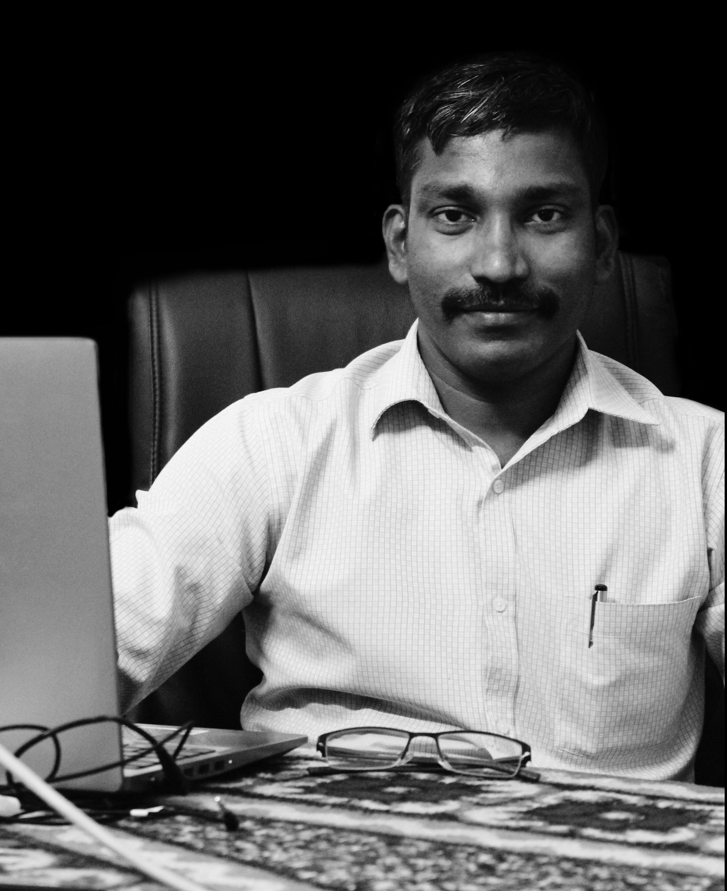 gray scale image of dhanesh sitting in his desk